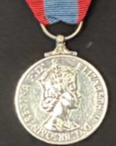 Close-up photograph of a lost Imperial Service Medal, displayed against a dark fabric background.